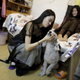 Online hostess Xianggong plays with a pet dog next to her mother, after a live broadcast at home